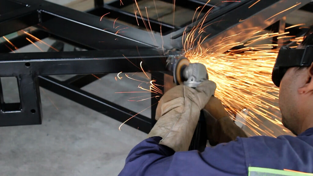 A person using a grinder to cut metal